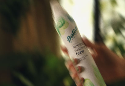 Woman showing how to use dry shampoo.