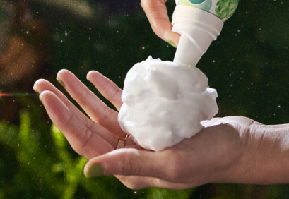 Woman spraying dry shampoo bottle.