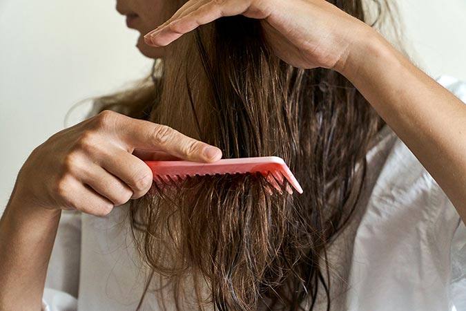 Woman combing through hair