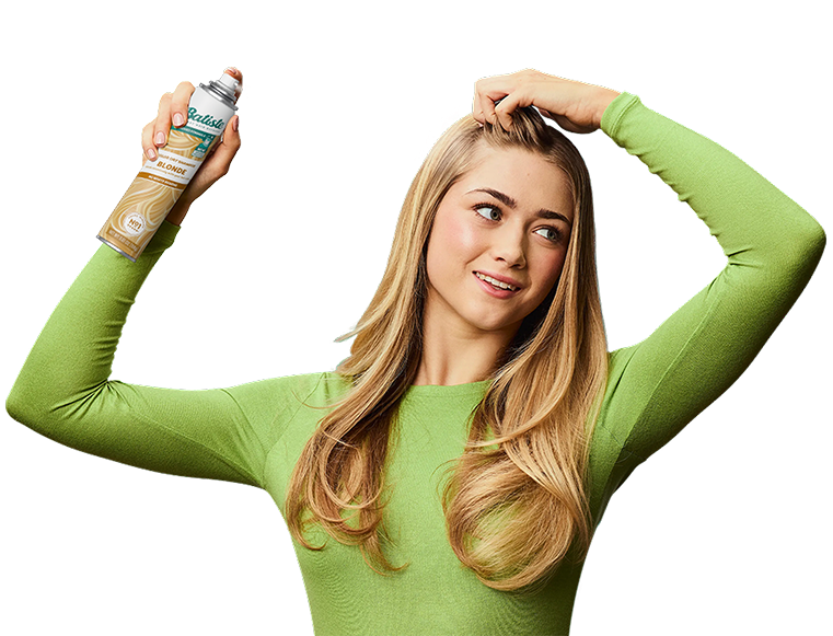 Woman spraying dry shampoo bottle.