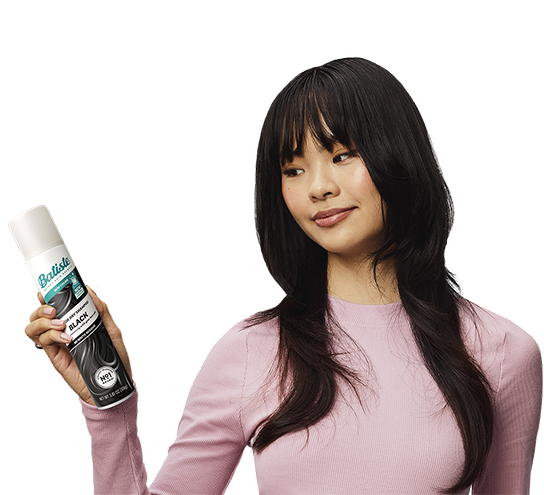 Woman showing how to use dry shampoo.
