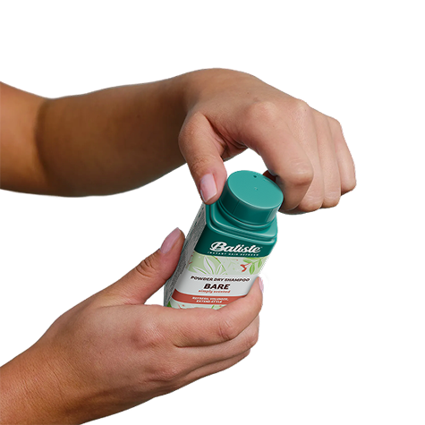 Woman showing how to use dry shampoo.
