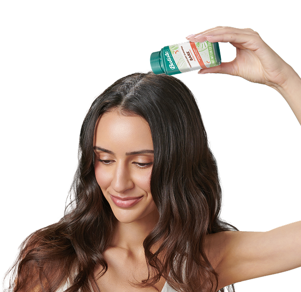 Woman spraying dry shampoo bottle.