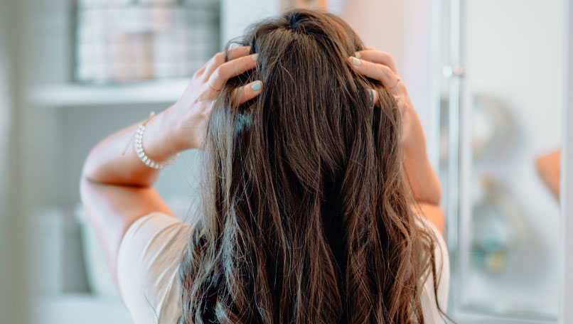 Woman putting hands in hair.