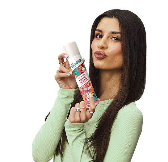 Woman showing how to use dry shampoo.