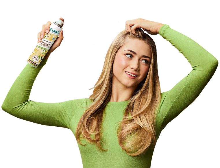 Woman spraying dry shampoo bottle.