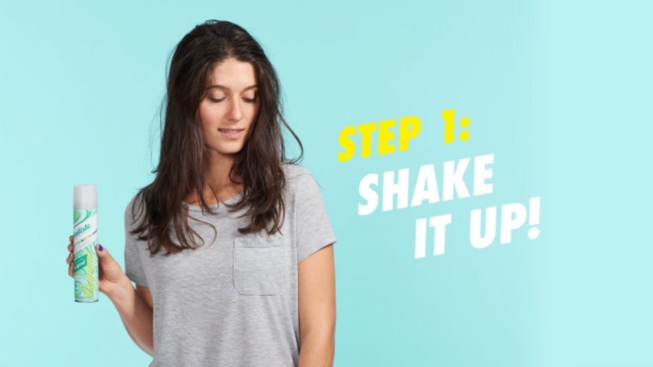 Woman showing how to use dry shampoo.