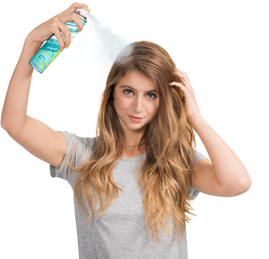 Woman spraying dry shampoo bottle.