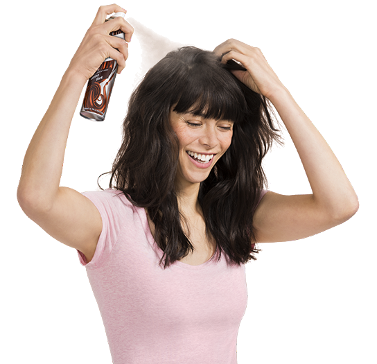 Woman spraying dry shampoo bottle.