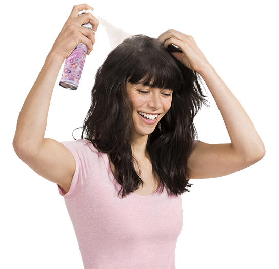 Woman spraying dry shampoo bottle.